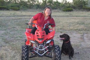 Manager Michelle doing a dawn run on the quad bike with happy four-legged company.
